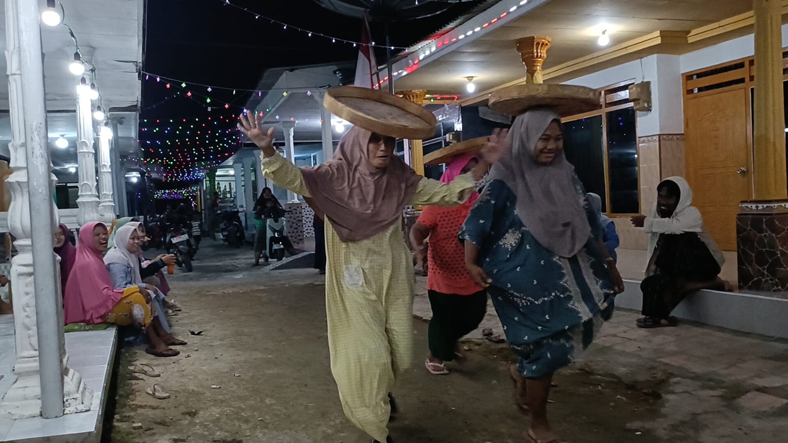 MENGHIBUR: Qorina (kiri), Nia, dan Masbiya (belakang) menghikuti lomba nyunggi tampah di Kampung Pocang Timur, Cangkreng, Kecamatan Lenteng, Rabu (13/8) malam.