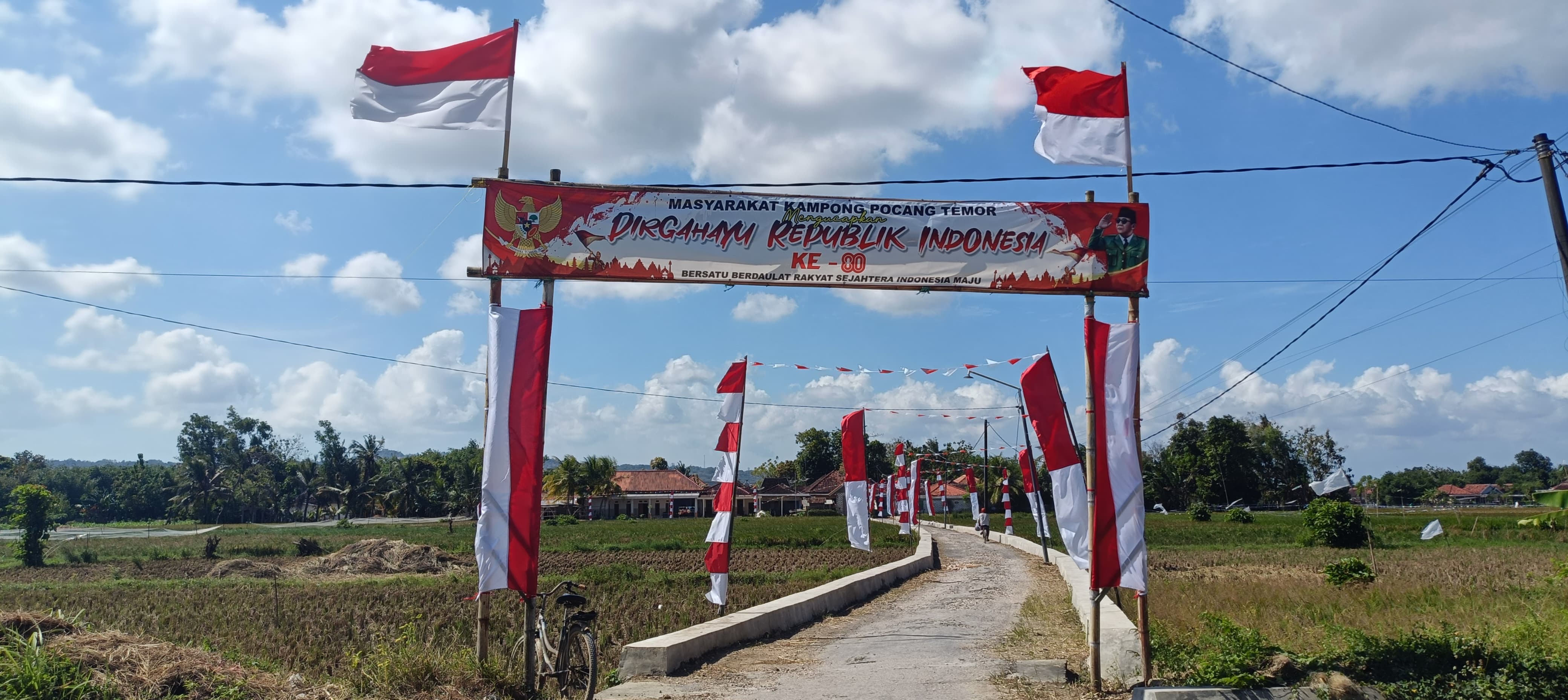 MERDEKA: Warga Cangkreng, Lenteng mengibarkan bendera hasil jahitan tukang jahit warga setempat.