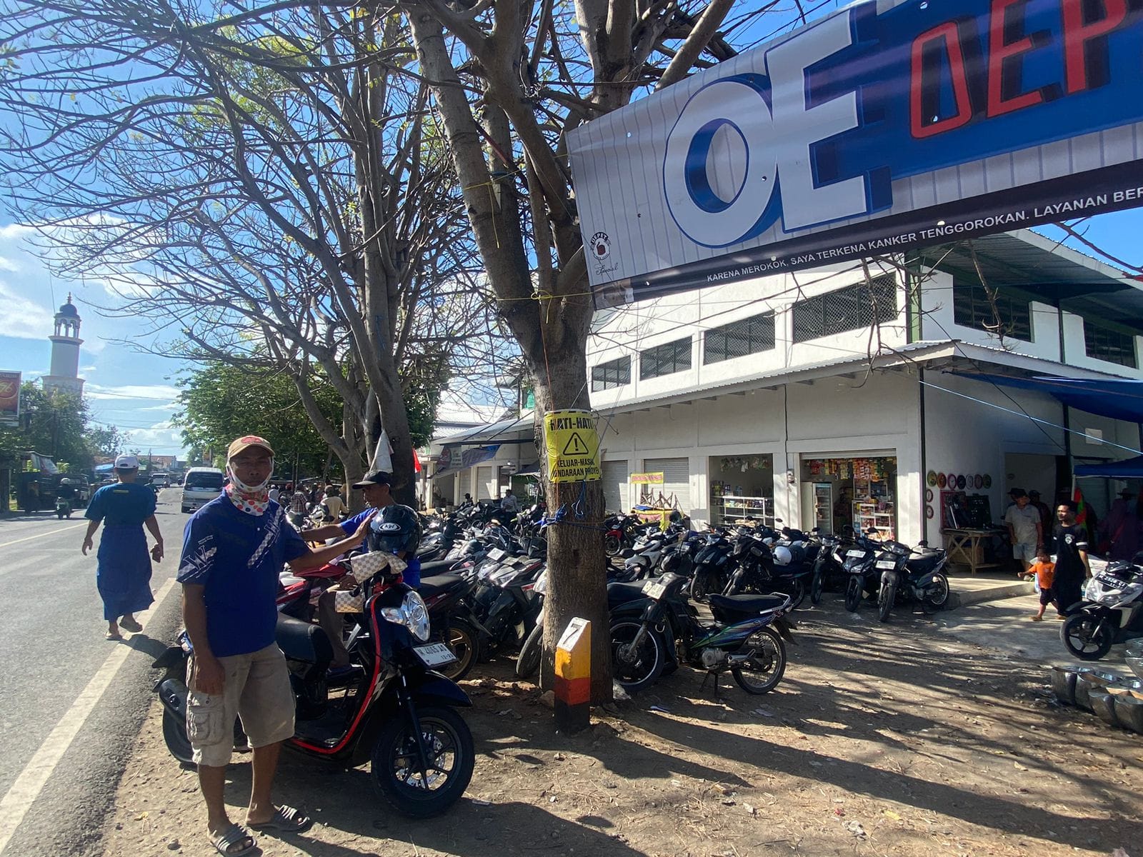 PENDAPATAN: Seorang pria sedang menjaga sepeda motor di lahan parkir yang ada di Pasar Keppo di Desa Polagan, Kecamatan Galis.