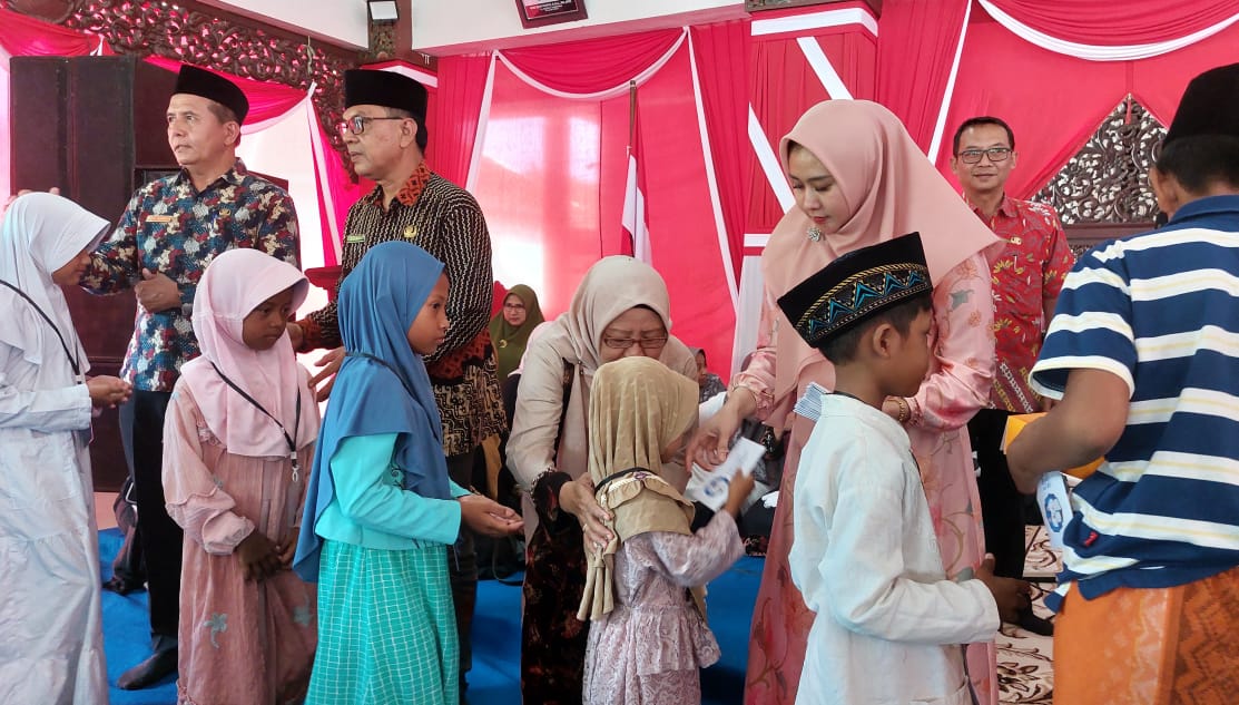 PENUH KASIH: Ketua TP-PPK Kabupaten Sampang Selviana Slamet Junaidi (tiga dari kanan) menyerahkan bantuan kepada anak yatim di Pendapa Trunojoyo Sampang, Kamis (21/8).