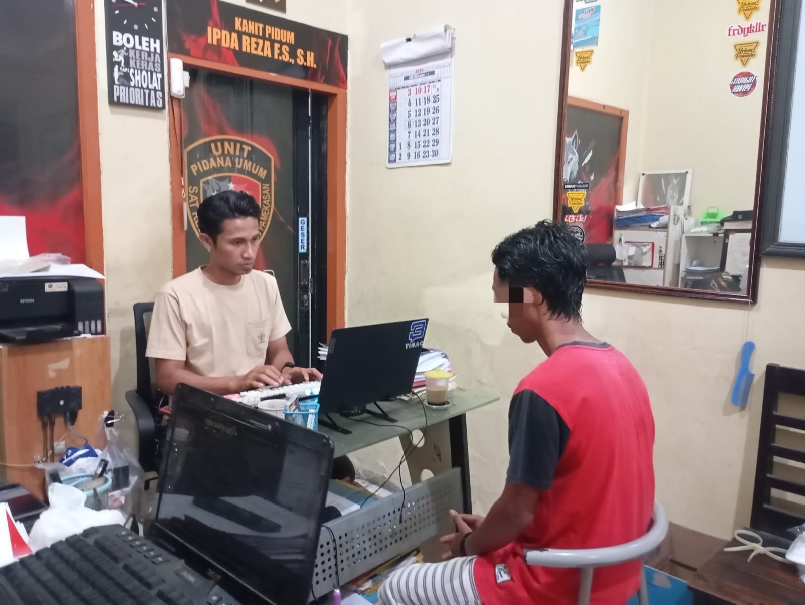 TERTUNDUK: Polisi menginterogasi terduga pelaku penganiayaan di ruang penyidik Satreskrim Polres Pamekasan, Rabu (20/8).