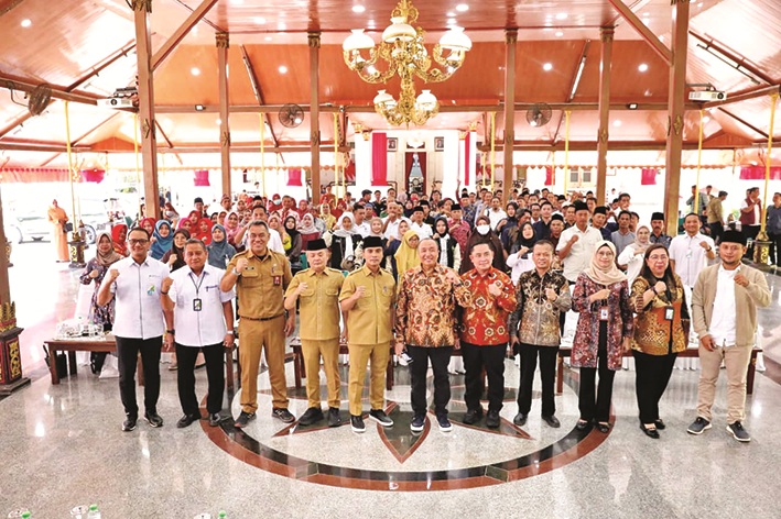 SOLID: Bupati Bangkalan Lukman Hakim didampingi Wabup Moch. Fauzan Ja&rsquo;far berfoto bersama dengan Dewas BPJamsostek dan peserta diskusi di Pendopo Agung Senin (25/8). (PROKOPIM UNTUK JPRM)