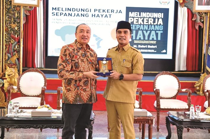 BERMITRA: Bupati Bangkalan Lukman Hakim menyerahkan cenderamata ke Ketua Dewas BPJamsostek Muhammad Zuhri Bahri di Pendopo Agung Senin (25/8). (PROKOPIM UNTUK JPRM)