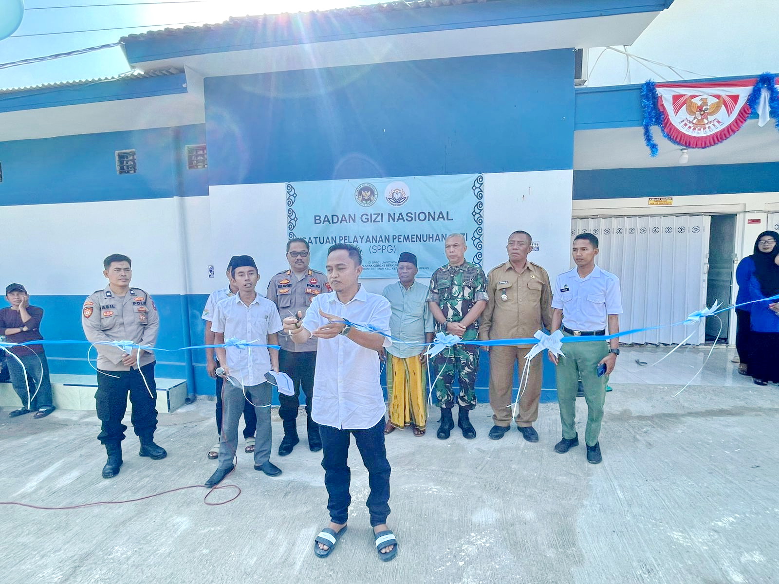 PENUH SEMANGAT: Joko Edi memotong pita sebagai simbol diresmikannya SPPG Yayasan Anak Cerdas Berkualitas Grup, Desa Bunten Timur, Kecamatan Ketapang, Sampang, Senin (25/8).