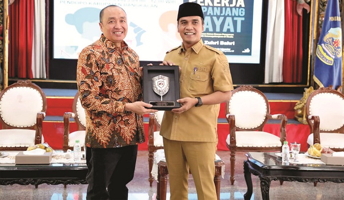 KENANG-KENANGAN: Ketua Dewas BPJS Ketenagakerjaan M. Zuhri Bahri menyerahkan cenderamata kepada Bupati Lukman Hakim di Pendopo Agung Bangkalan, Senin (25/8). (BPJS KETENAGAKERJAAN UNTUK JPRM)