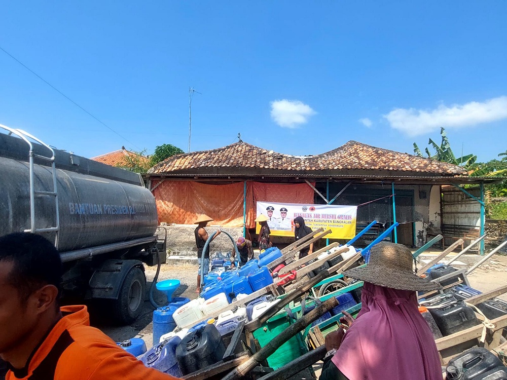 TERDAMPAK KEKERINGAN: Masyarakat Desa Kelapayan, Kecamatan Sepulu, tengah antre mendapatkan pendistribusian air bersih Selasa (5/8).