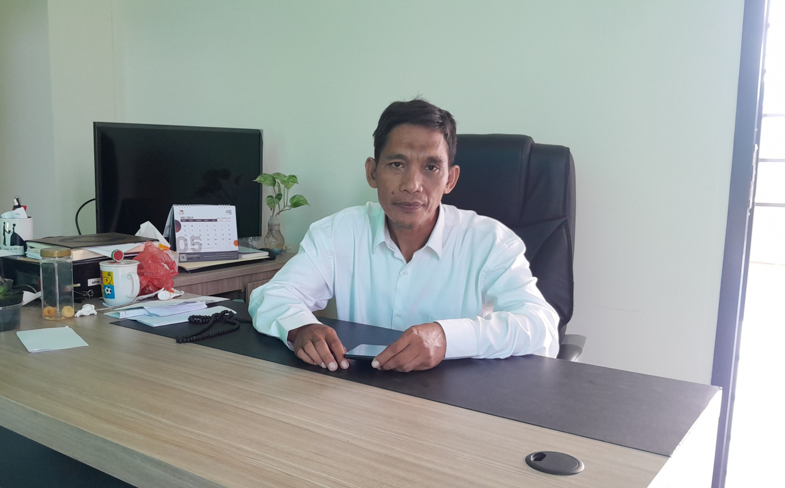 SANTAI: Kasi Penyelenggaraan Haji dan Umrah (PHU) Kemenag Bangkalan Arif Rochman saat ditemui di ruang kerjanya, Jumat (29/8).