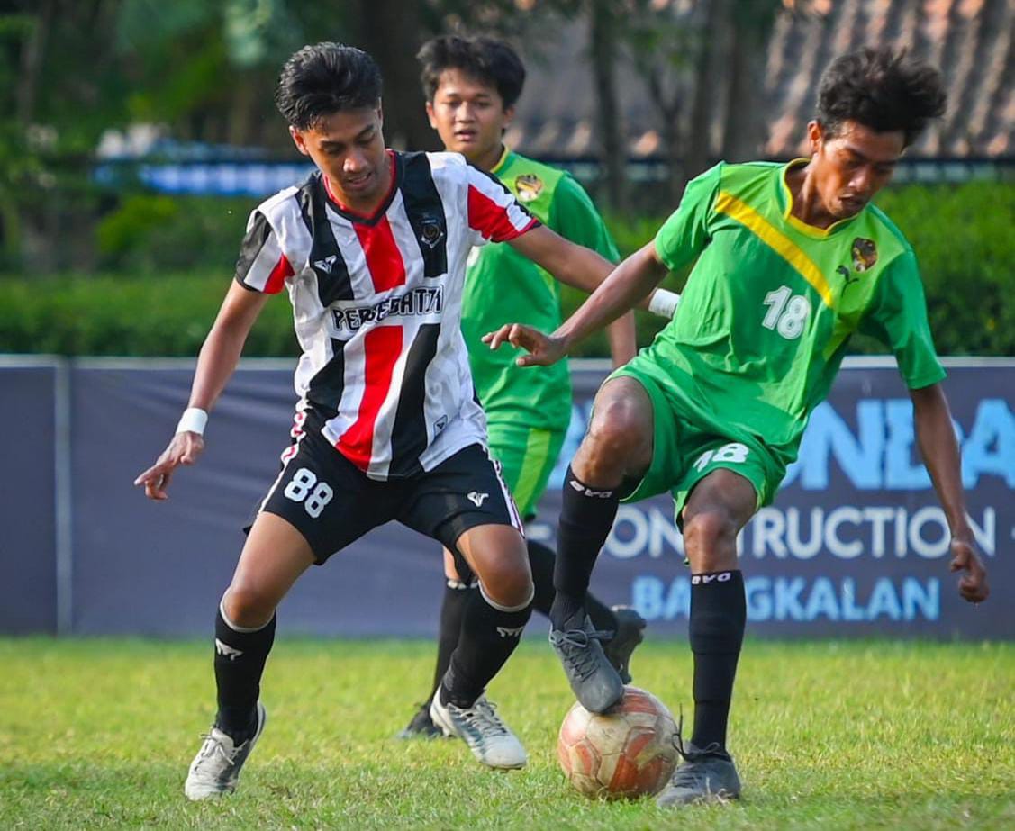DITEMPEL KETAT: Pemain Persetan FC (jersi merah putih) berusaha merebut bola dari kaki pemain Mitra FC saat bertanding lapangan Alun-Alun Bangkalan, Sabtu (16/8).