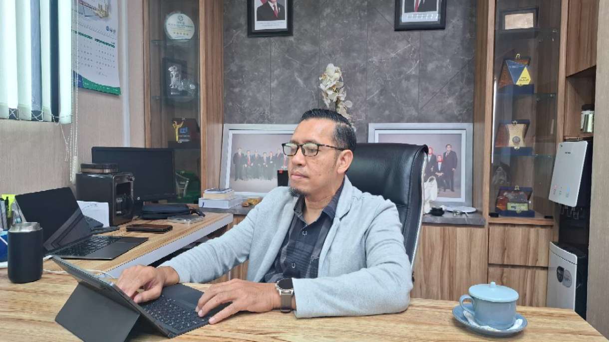 PANTAU: Kepala BPJS Kesehatan Cabang Pamekasan, Nuzuludin Hasan mengecek laporan di kantornya.