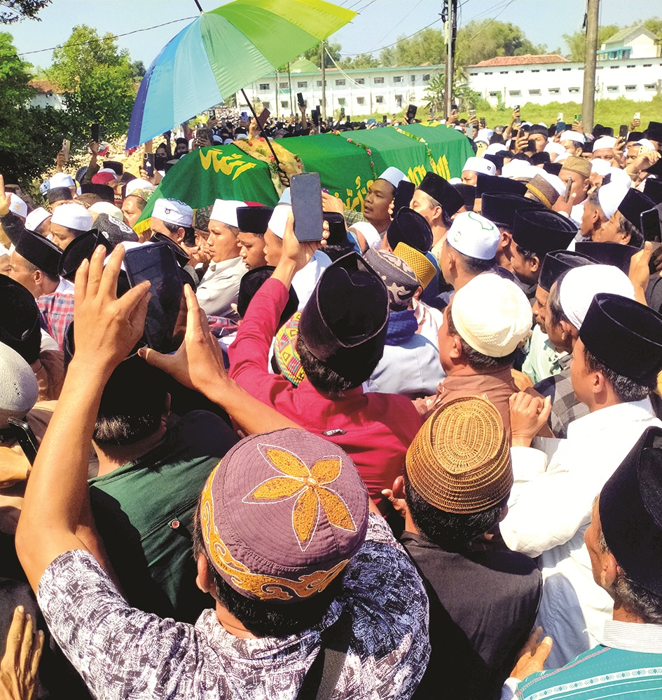 BERDUKA: Ribuan alumni dan masyarakat mengantarkan jenazah almarhum KH Abd. Muhaimin bin Abd. Bari ke area pemakaman keluarga Ponpes Darut Tauhid, Sampang, Jumat (5/9). (MOH. SUBHAN/JPRM)