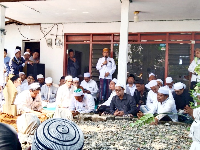 PENGHORMATAN: Ketua Tanfidziyah PCNU Sampang KH Moh. Itqan Bushiri menyampaikan sambutan usai pemakaman KH Abd. Muhaimin bin Abd. Bari Jumat (5/9). (MOH. SUBHAN/JPRM)