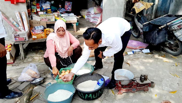 CEK HARGA: Petugas Pasar Senenan, Bangkalan, sedang mengontrol harga beras di pedagang Senin (8/9). (M. KHOLIL RAMLI/JPRM)