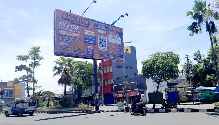 OBJEK PAJAK: Kendaraan bermotor melintas di sekitar reklame di Jalan Jenderal A. Yani Bangkalan Senin (8/9). (M. KHOLIL RAMLI/JPRM)