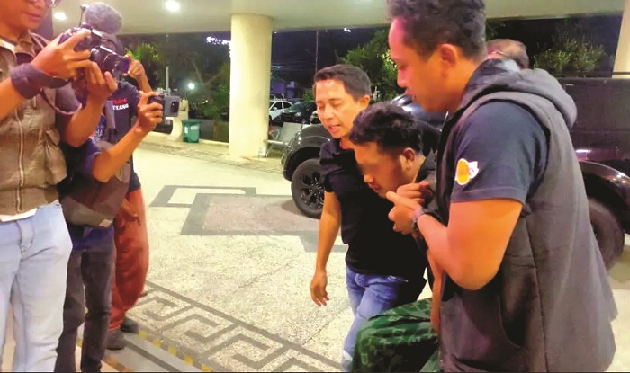 DILUMPUHKAN: Anggota Polri saat menggiring tersangka ke kantor Mapolda Jatim.