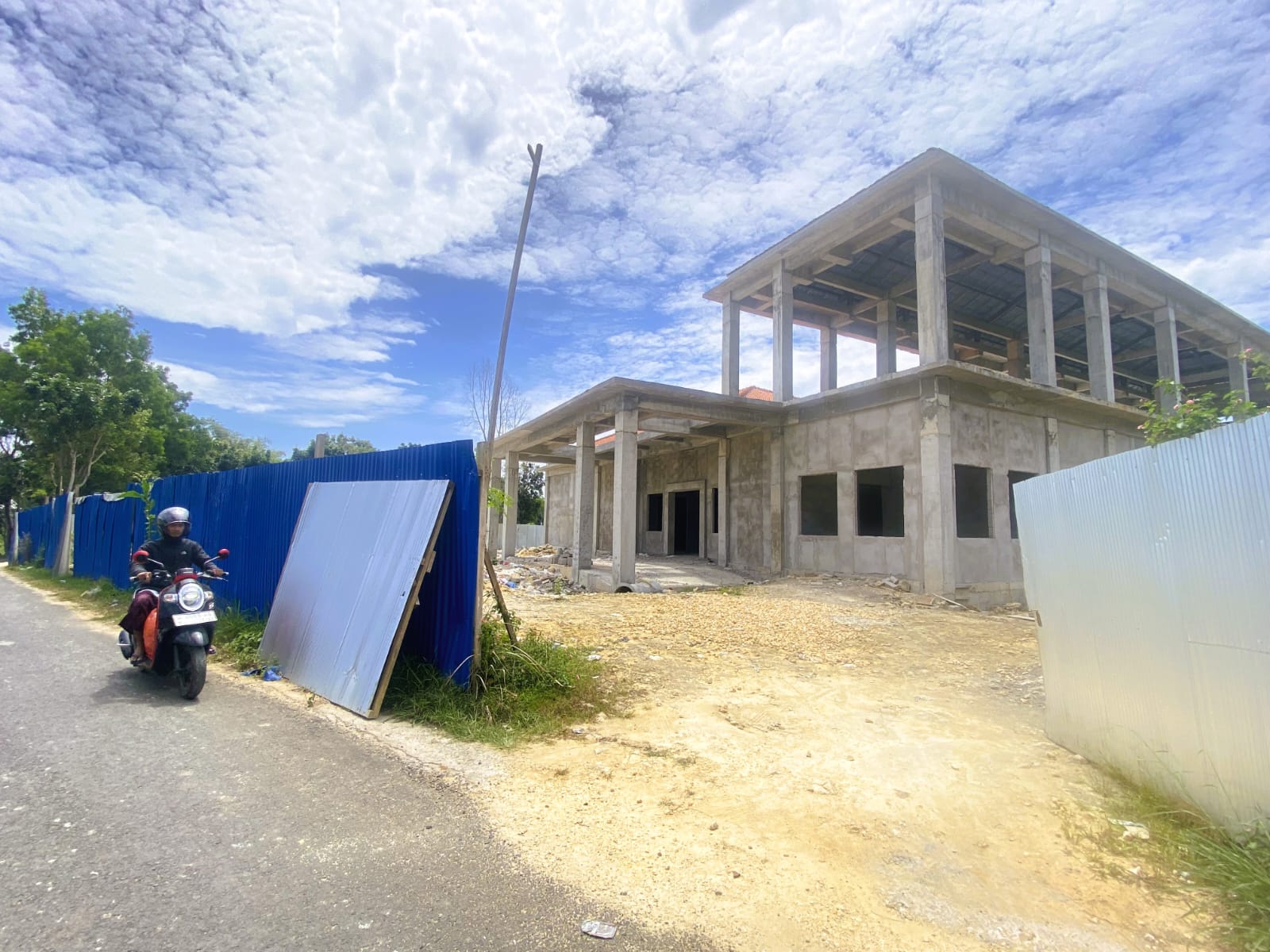 PEMBANGUNAN: Warga melintas didepan proyek pembangunan Puskesmas Bulangan Haji, Desa Tlagah, Kecamatan Pagantenan, Minggu (7/9).