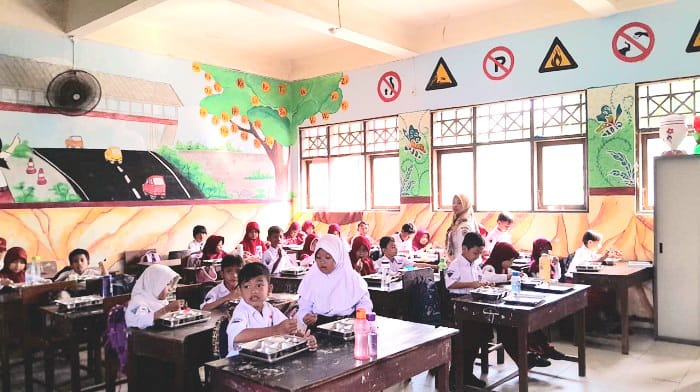 ANTUSIAS: Siswa SD Negeri Mlajah 2 Bangkalan sedang menikmati menu makan bergizi gratis, Selasa (26/8). (M. KHOLIL RAMLI/JPRM)