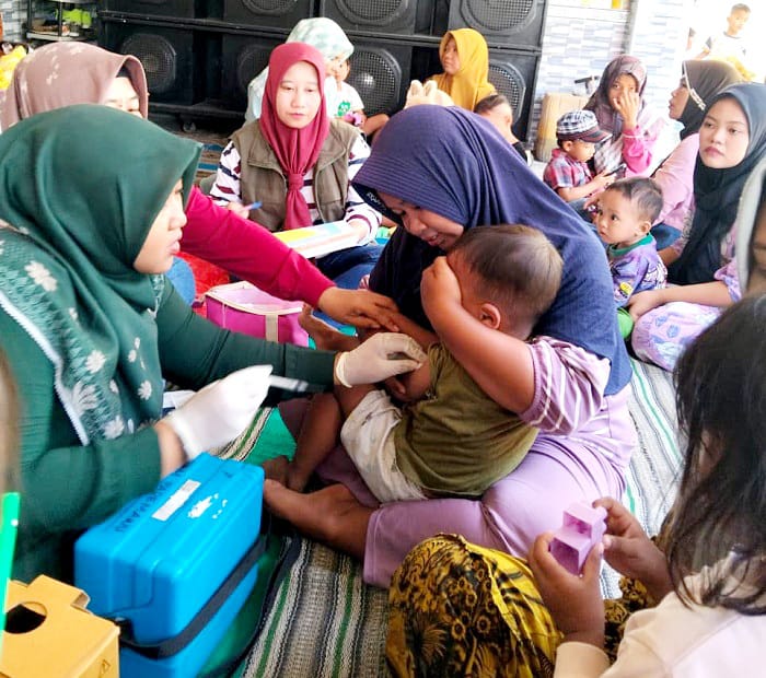 DEMI KESEHATAN: Petugas Puskesmas Pademawu, Pamekasan, melakukan imunisasi campak pada anak Minggu (14/9). (DINKES UNTUK JPRM)
