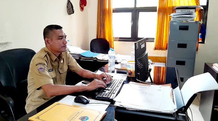 TUNJUKKAN DATA: Kepala Bidang Linjamsos Dinsos Bangkalan Mohammad Aminullah saat ditemui di ruang kerjanya, Selasa (2/9). (M. KHOLIL RAMLI/JPRM)