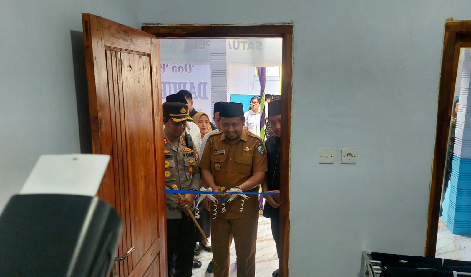 SIMBOLIS: Wakil Bupati Sampang Ahmad Mahfudz menggunting pita sebagai tanda diresmikannya SPPG Yayasan Rumah Juang Emas di Desa Pangongsean, Kecamatan Torjun, Sampang, Senin (15/9).