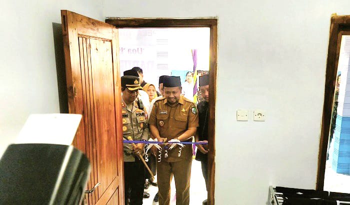 SIMBOLIS: Wabup Sampang Ahmad Mahfudz menggunting pita sebagai tanda peresmian dapur Jimad Sakteh Desa Pangongsean, Kecamatan Torjun, Senin (15/9). (JUNAIDI PONDIYANTO/JPRM)