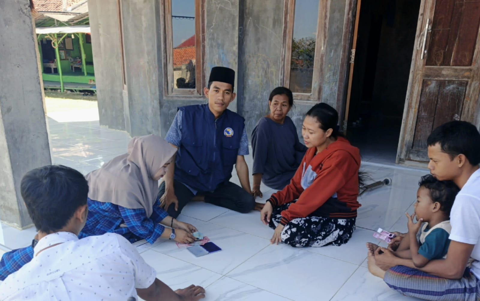 MELAYANI: Petugas sedang melakukan proses penyaluran bantuan disabilitas dengan mengantarkan ke kediaman penerima di wilayah Kecamatan Camplong Senin (11/8)