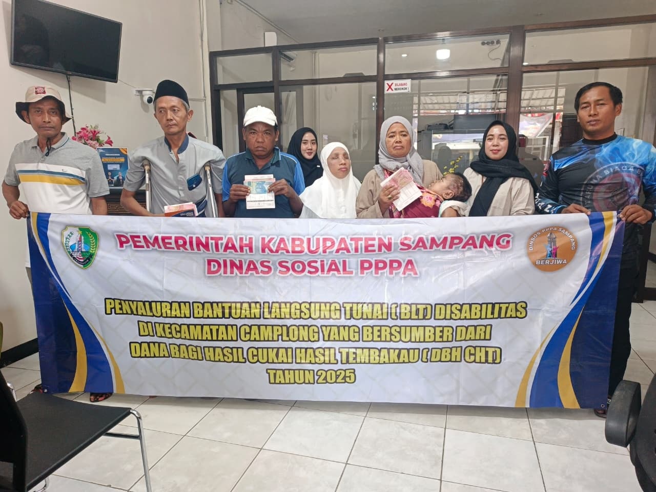 SIMBOLIS: Petugas bersama sejumlah penerima saat penyaluran bantuan disabilitas di wilayah Kecamatan Camplong Rabu (13/8)
