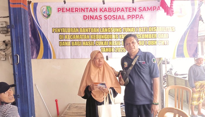 SIMBOLIS: Petugas berfoto dengan salah satu penerima usai mencairkan bantuan disabilitas di Kecamatan Kedungdung, Rabu (13/8). (DINSOS PPA UNTUK JPRM)
