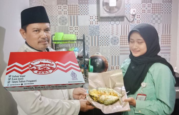 Kepala Desa Junok H. Ach Fathoni saat menunjukkan hasil olahan produk Bandeng Junok Beda yang digagas Tim Dosen UTM dalam program Abdimas DRTPM.