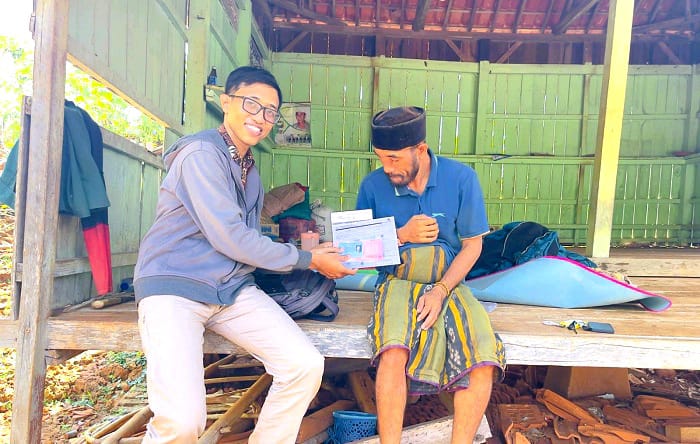 PENERIMA MANFAAT: Petugas menyerahkan bantuan di rumah penerima karena tidak bisa mengambil langsung ke bank di Kecamatan Sokobanah, Senin (22/9). (DINSOS PPPA UNTUK JPRM)