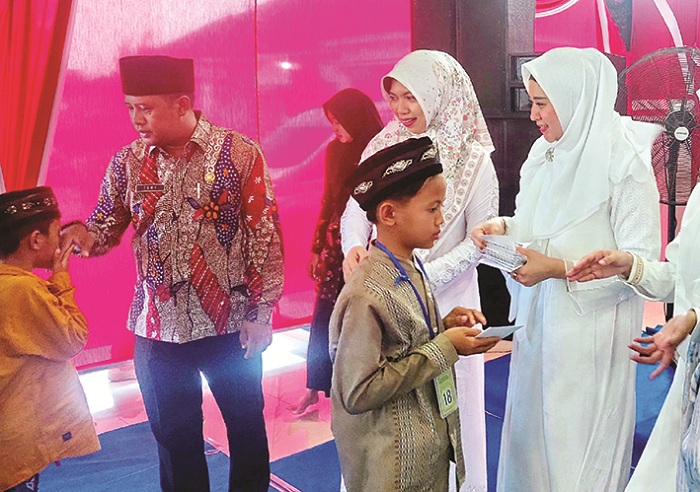 PENUH KASIH: Ketua TP PPK Sampang Selviana Slamet Junaidi (kanan) menyalurkan santunan anak yatim di Pendopo Trunojoyo, Kamis&nbsp;(25/9). (JUNAIDI PONDIYANTO/JPRM)