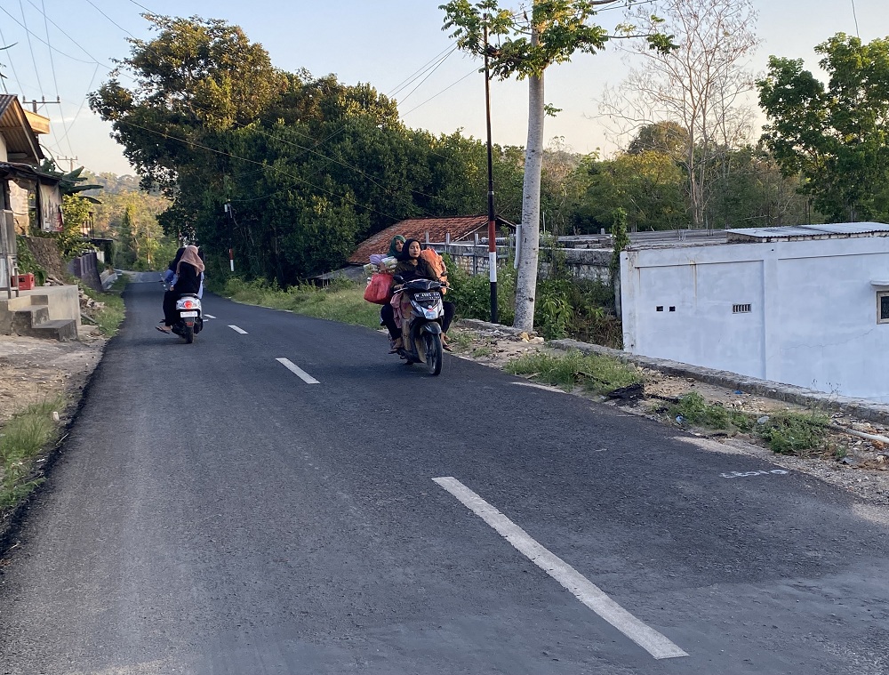 DIALIHKAN: Pengendara motor melintas jalan Desa Kertagena Tengah usai diperbaiki pada Jumat (19/9).