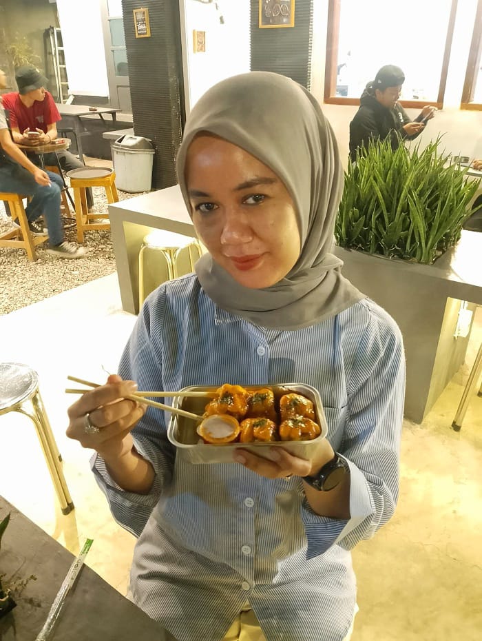 MENIKMATI: Pengunjung Kafe Niki Kopi Dien Faradhila menikmati dimsum yang dipesannya, Kamis (11/9). (UBAIDILLAHIR RAIE/JPRM)