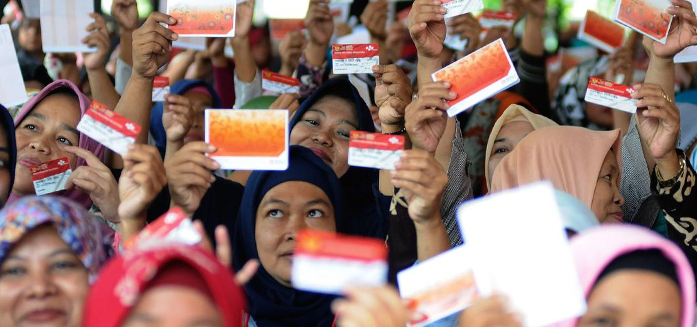 Warga menunjukkan kartu rekening bansos PKH, BPNT.
