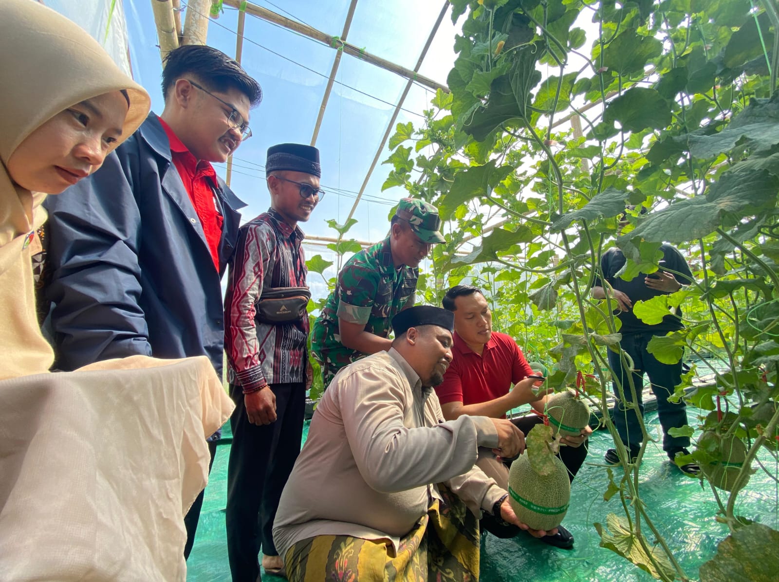ANTUSIAS: Camat Waru Dwi Nurcholish Ikhwan (kaus merah), Kades Waru Barat Abdussalam Ramli (kopiah hitam) dan Kepala SMK Darul Amin Moh. Ramli (batik) memetik melon, Sabtu (27/9).