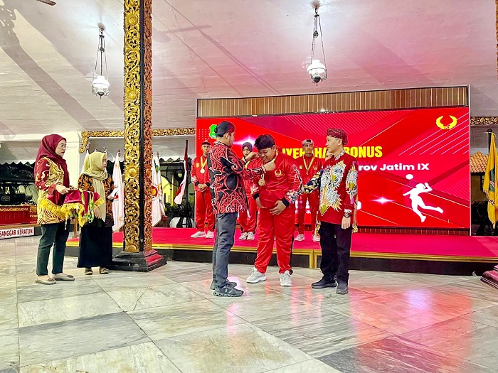 APRESIASI: Bupati Achmad Fauzi Wongsojudo mengalungkan medali kepada atlet porprov saat acara pemberian bonus di Pendopo Agung Keraton Sumenep pada Selasa (30/9) malam. (MOH. IQBAL/JPRM)