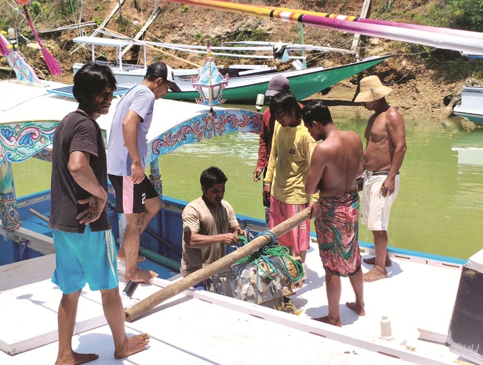 KOMPAK: Sejumlah nelayan gotong royong mengangkut mesin di sungai Desa Tlontoraja, Kecamatan Pasean, Pamekasan, Jumat (3/10). (AYU LATIFAH/JPRM)