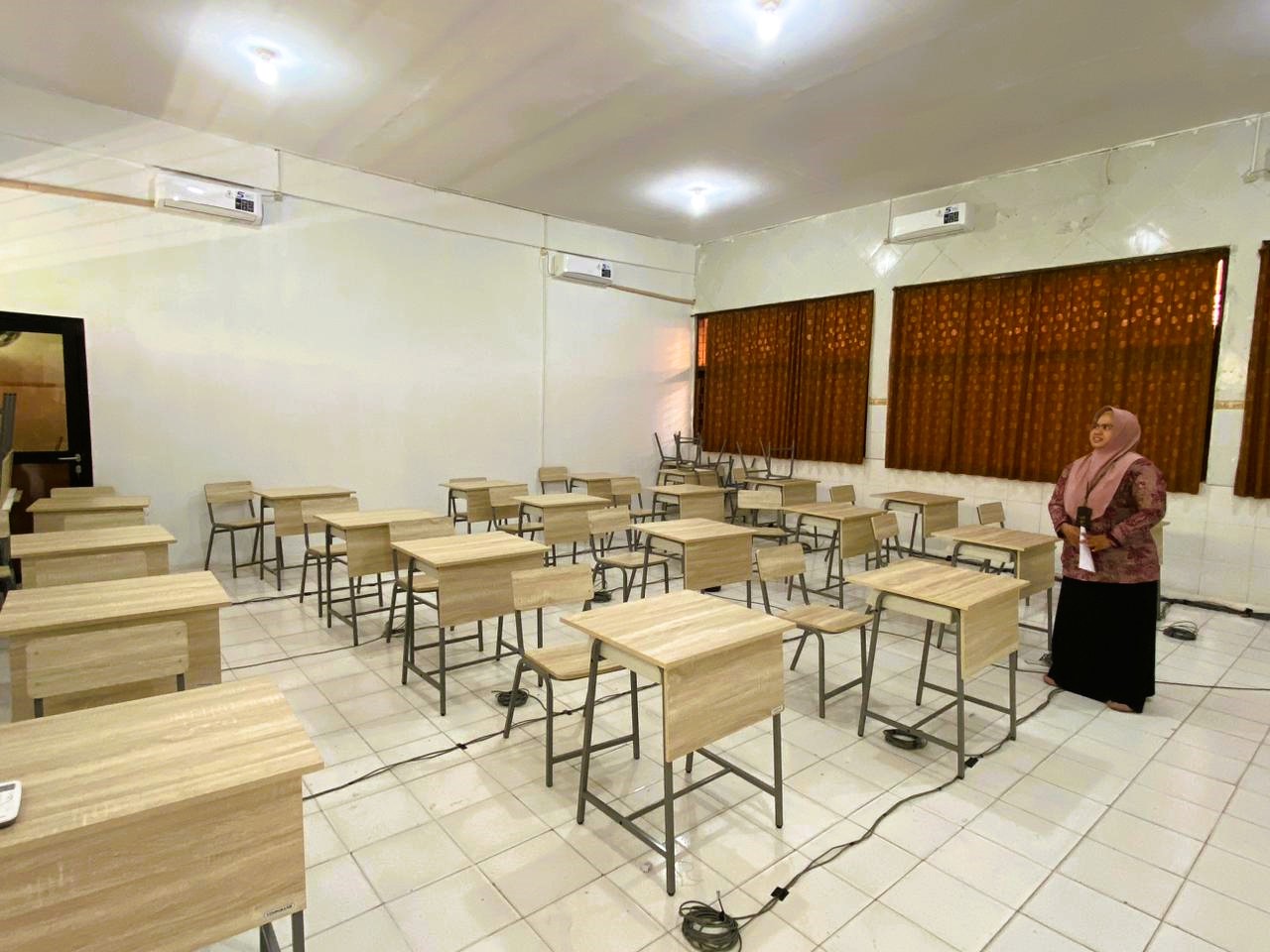 SARANA: Aisyah Minarni Mukti saat menata kursi di Lab Komputer di SRMP Kecamatan Pademawu Kamis (2/10).