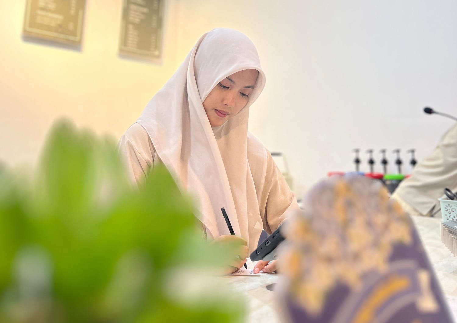 MANIS: Tria mengecek menu di Kafe Hooki.