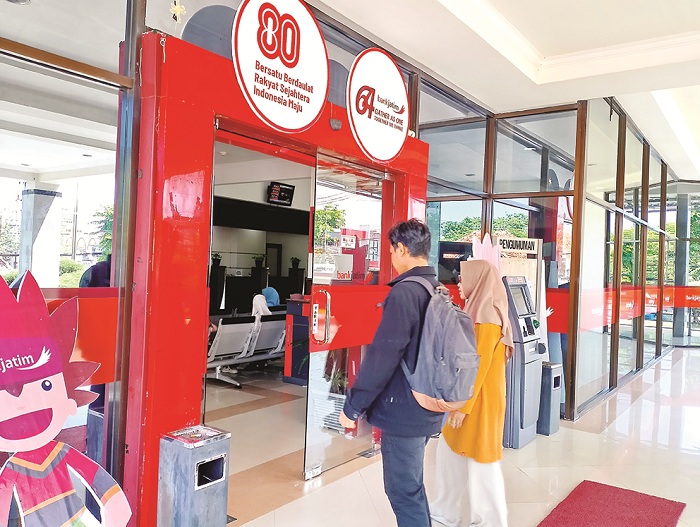 LAYANAN PUBLIK: Warga berada di halaman kantor Bank Jatim Cabang Sampang Rabu (8/10). (UBAIDILLAHIR RAIE/JPRM)