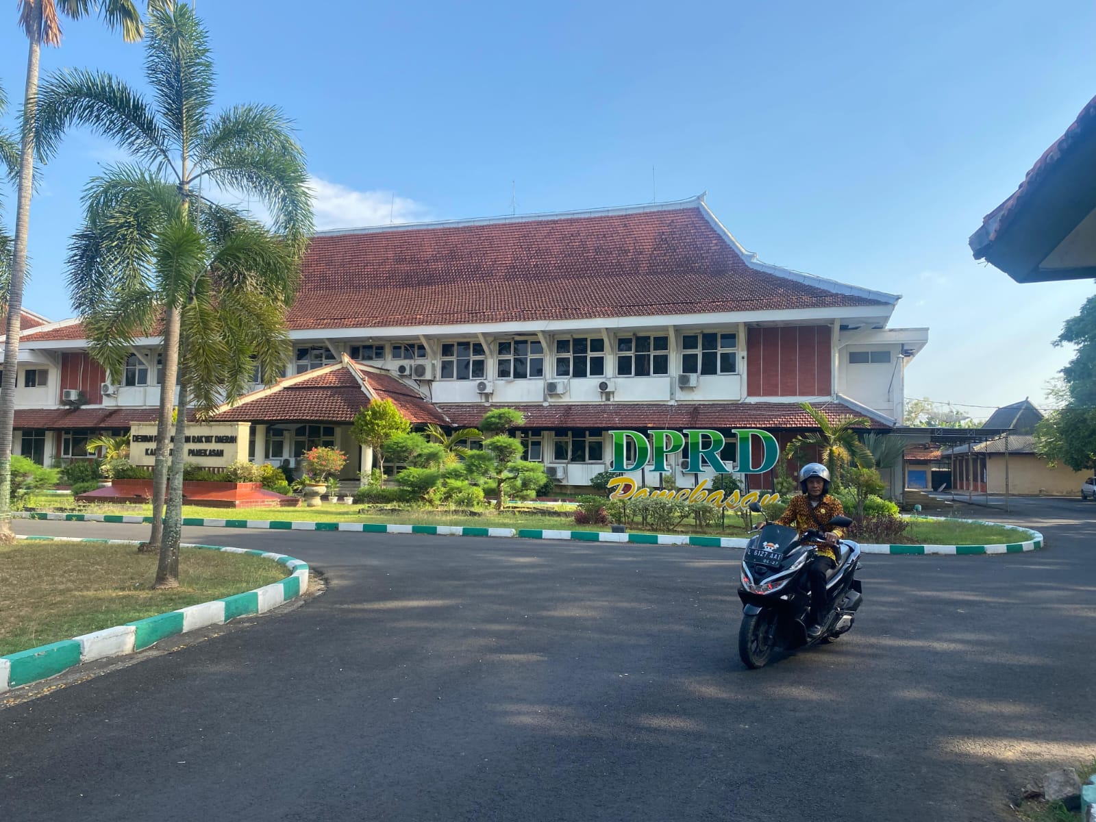 JAM PULANG: Warga melintas di depan kantor DPRD Pamekasan, Kamis (9/10).