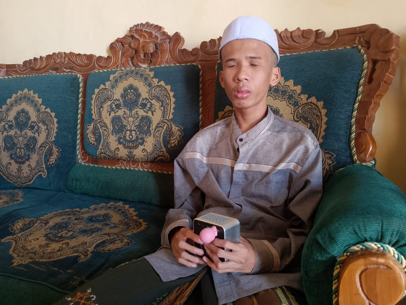 TELADAN: Abi Yaqub menyimak murottal menggunakan pemutar lagu yang digunakannya untuk menghafal Al-Quran di rumahnya, Jumat (10/10)