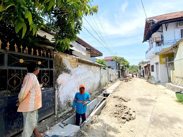 TERIK: Tukang mengerjakan drainase di Kelurahan Patemon, Kecamatan Kota Pamekasan, Senin (6/10). (AYU LATIFAH/JPRM)