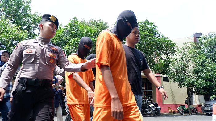 TERSANGKA: Aparat menggiring dua terduga pelaku tindak pidana pencabulan di Mapolres Bangkalan Selasa (14/10). (VIVIN AGUSTIN HARTONO/JPRM)