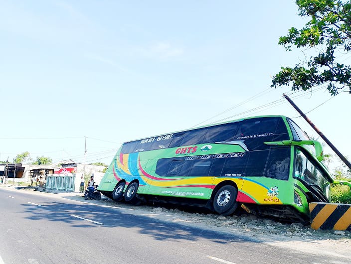 TERPEROSOK: Bus Gunung Harta belum dievakuasi usai terlibat laka di jalan raya Desa Dharma Camplong, Kecamatan Camplong, Sampang, Rabu (8/10). (UBAIDILLAHIR RAIE/JPRM)