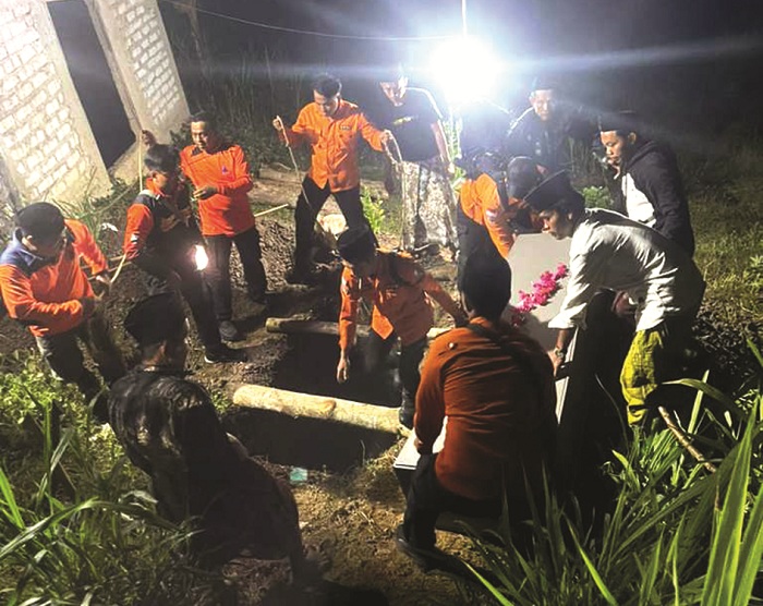 BERDUKA: Warga dan tim BPBD Sampang mengikuti proses penguburan korban di Desa Desa Lepelle, Kecamatan Robatal, Rabu (15/10). (BPBD UNTUK JPRM)