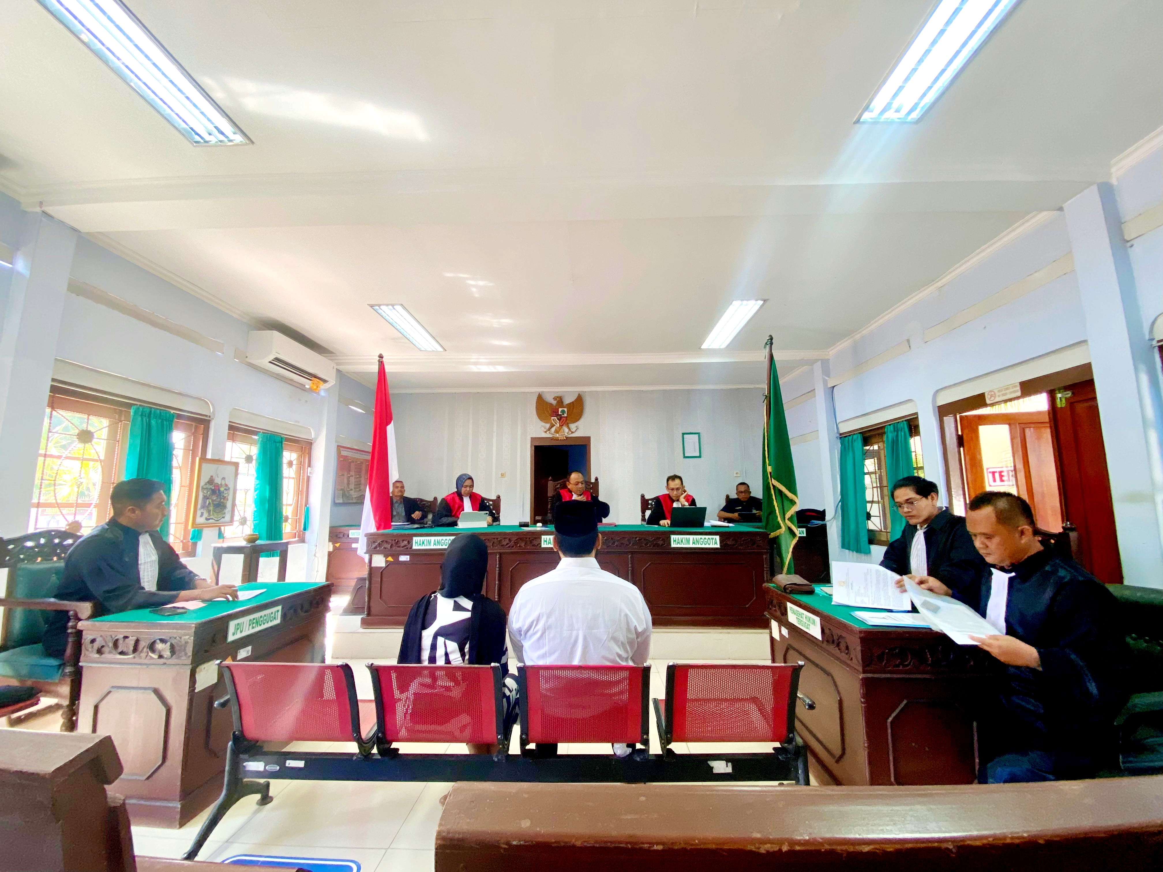 SIDANG PERDANA: Terdakwa Zainal Arifin dan Siti Kholisah duduk di bangku terdakwa Pengadilan Negeri Pamekasan Rabu (15/10). (MOH. IQBAL AFGANI/JPRM)