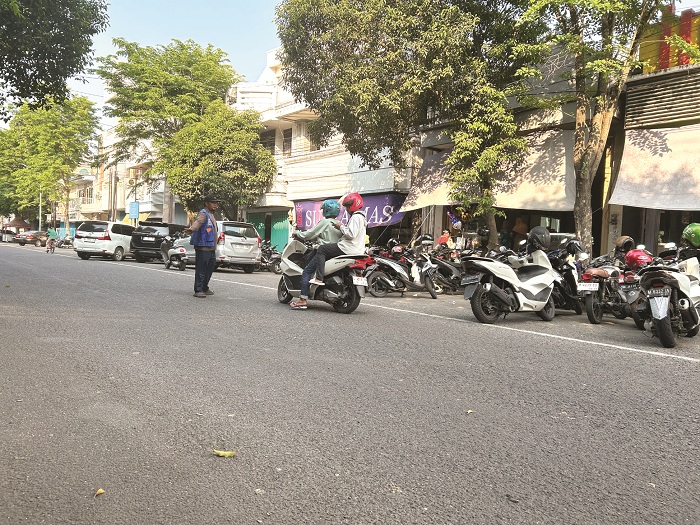 PERLU DIEVALUASI: Juru parkir (jukir) mengawal pengguna jasa parkir di Jalan Panglima Sudirman Bangkalan Kamis (16/10). (VIVIN AGUSTIN HARTONO/JPRM)