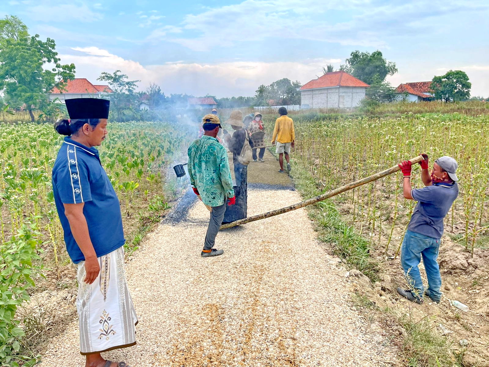 GOTONG ROYONG: Mat Yasin meninjau perbaikan jalan Dusun Berleber, Desa Madulang, Kecamatan Omben, Sampang, Minggu (19/10) sore.