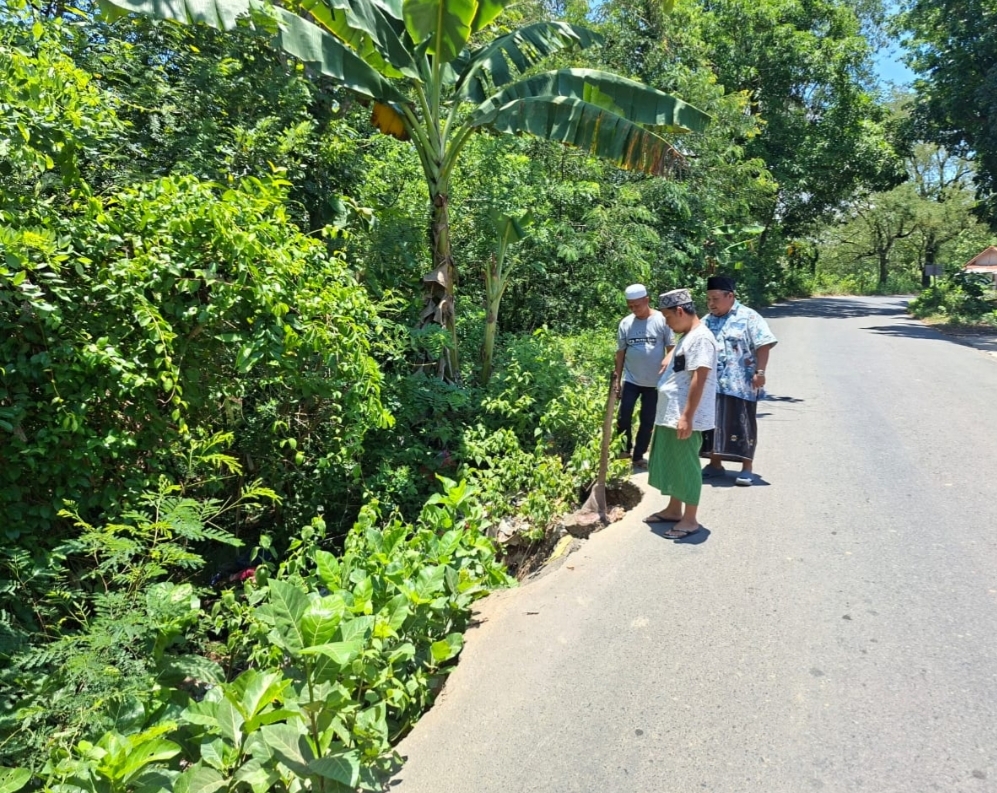 MEMBAHAYAKAN: Anggota DPRD Sampang Fathurrosi (songkok hitam) bersama warga mengecek jalan longsor di Desa Tlambah, Kecamatan Karang Penang, Sampang, Kamis (16/10).