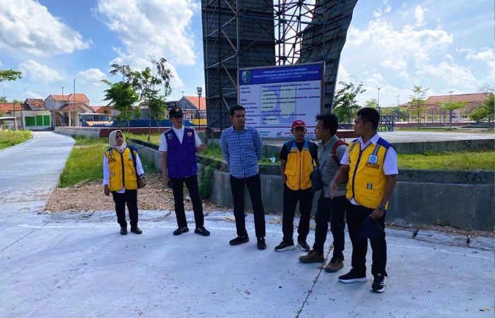 CEK LAPANGAN: Kepala DPUPR Sampang Mohammad Zis didampingi Kabid Air Minum dan Penyehatan Lingkungan (AMPL) Siti Muatifah memantau proyek rekonstruksi Jalan Imam Bonjol, Kelurahan Dalpenang, Sampang.